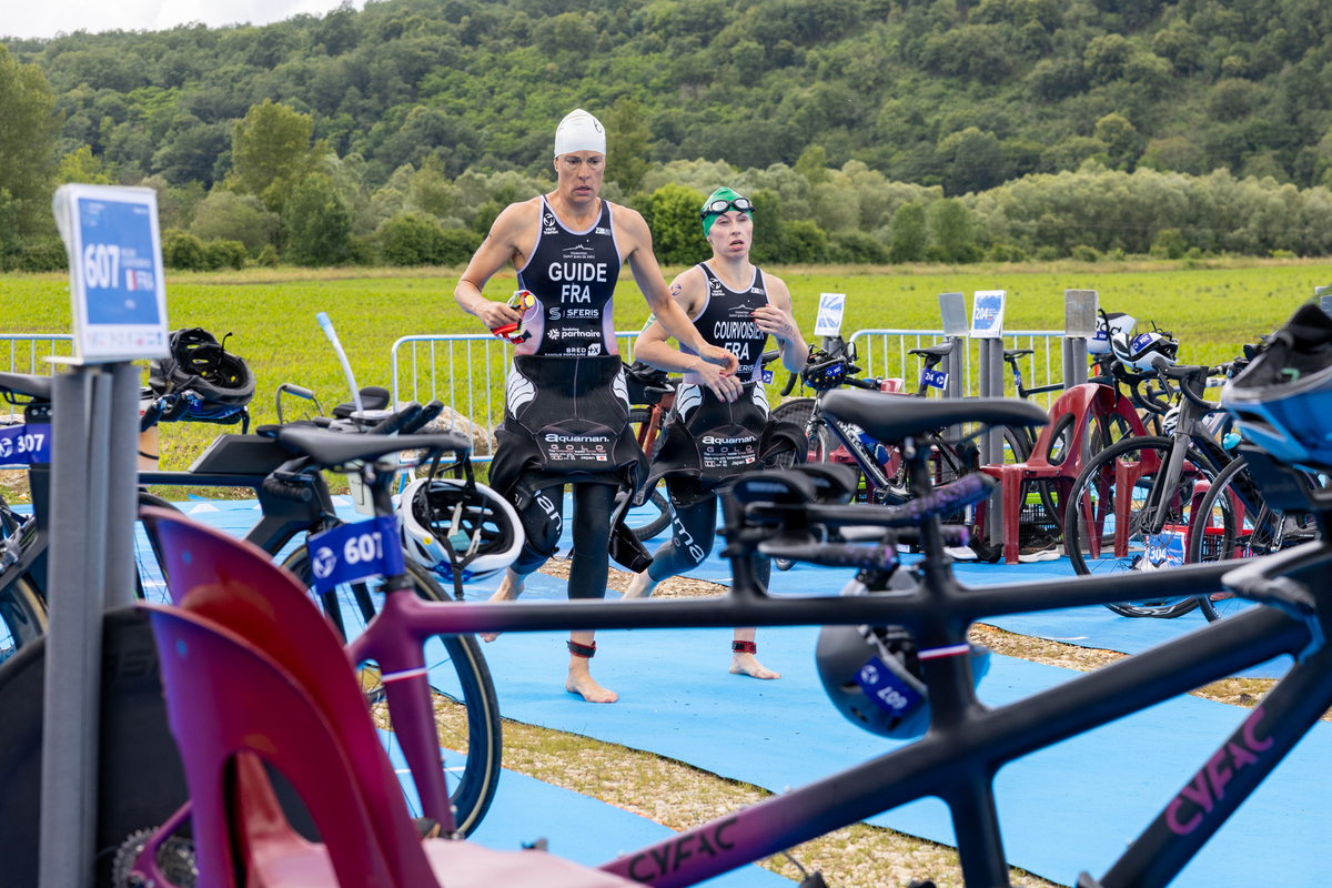 Reliée par un élastique, Anne passe devant Héloïse au moment de la transition entre la nage et le vélo -  Photo Xavier Ducordeaux